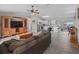 Open-concept living room with wood-look floors connecting to a bright kitchen with white cabinets at 4660 Se 142Nd Ln, Summerfield, FL 34491