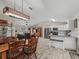 Open living space with kitchen, living room, and dining area, featuring wood-look tile floors throughout at 4660 Se 142Nd Ln, Summerfield, FL 34491