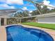 Backyard pool surrounded by a screened enclosure and green landscaping offers a private oasis at 4660 Se 142Nd Ln, Summerfield, FL 34491