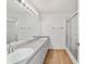 Bright bathroom featuring double sinks, a large mirror, and a tiled shower at 475 Ne 155Th Pl, Citra, FL 32113