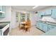 Bright kitchen featuring a charming breakfast nook with large windows and blue cabinets at 475 Ne 155Th Pl, Citra, FL 32113