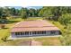 Rear aerial view of a home boasting a red tile roof, sunroom and expansive greenery at 475 Ne 155Th Pl, Citra, FL 32113