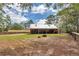 Exterior backyard view of log cabin with a metal roof, covered porch, and natural landscape at 5630 Se 183Rd Avenue Rd, Ocklawaha, FL 32179