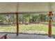 Covered patio overlooking the backyard with a fire pit and wooded views at 5630 Se 183Rd Avenue Rd, Ocklawaha, FL 32179