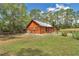 Log cabin with expansive backyard and lush green lawn, perfect for outdoor activities and serene relaxation at 5630 Se 183Rd Avenue Rd, Ocklawaha, FL 32179