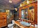 Rustic bathroom featuring wood walls and vanity, metal basin sink, and farmhouse decor at 5630 Se 183Rd Avenue Rd, Ocklawaha, FL 32179
