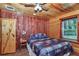 Charming bedroom featuring wood paneling, a ceiling fan, and natural light at 5630 Se 183Rd Avenue Rd, Ocklawaha, FL 32179