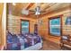Cozy bedroom featuring wood paneling, ceiling fan, and natural light at 5630 Se 183Rd Avenue Rd, Ocklawaha, FL 32179