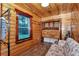Bedroom with rustic wood walls, comfortable seating, and convenient laundry area behind wooden doors at 5630 Se 183Rd Avenue Rd, Ocklawaha, FL 32179