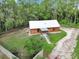 Charming log cabin with metal roof, green lawn, and perimeter fence offers rustic appeal and modern convenience at 5630 Se 183Rd Avenue Rd, Ocklawaha, FL 32179