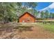 Rear view of cozy log cabin with covered patios, offering a tranquil retreat surrounded by lush greenery at 5630 Se 183Rd Avenue Rd, Ocklawaha, FL 32179