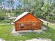 An aerial view of a charming log cabin with lush surrounding greenery at 5630 Se 183Rd Avenue Rd, Ocklawaha, FL 32179