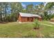 Secluded log cabin with metal roof surrounded by lush greenery, offering privacy and tranquility on expansive grounds at 5630 Se 183Rd Avenue Rd, Ocklawaha, FL 32179