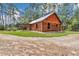 Exterior view of log cabin showing metal roof, covered porch, and fenced yard at 5630 Se 183Rd Avenue Rd, Ocklawaha, FL 32179