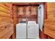 Laundry area with a washer and dryer, wood cabinets, and a shower in a wood-paneled room at 5630 Se 183Rd Avenue Rd, Ocklawaha, FL 32179