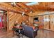 Comfortable living room with wood-paneled walls, ceiling fan, and a deer head mount at 5630 Se 183Rd Avenue Rd, Ocklawaha, FL 32179