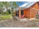 View of the covered porch with log cabin architecture and outdoor seating area at 5630 Se 183Rd Avenue Rd, Ocklawaha, FL 32179