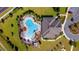 Aerial view of a community pool, lounge chairs, green space, and building at 6299 Sw 90Th St, Ocala, FL 34476