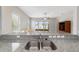 Kitchen bar top overlooks the living room, complemented by granite counters and stainless steel sink at 6299 Sw 90Th St, Ocala, FL 34476