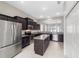 Bright, spacious kitchen with stainless steel appliances and dark wood cabinetry, open to the living area at 6299 Sw 90Th St, Ocala, FL 34476