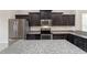 Modern kitchen with stainless steel appliances, dark cabinets, granite countertops, and tiled floors at 6299 Sw 90Th St, Ocala, FL 34476