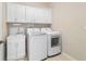 Bright laundry room featuring a modern washer and dryer, white cabinets, and utility sink at 6299 Sw 90Th St, Ocala, FL 34476