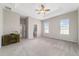 Bright main bedroom with a desk and two windows, leading to a closet and ensuite bathroom at 6299 Sw 90Th St, Ocala, FL 34476