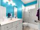 Bright blue bathroom featuring a shower-tub combo, large vanity, and a white toilet at 6551 Se 11Th Loop, Ocala, FL 34472