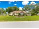 Charming one-story home featuring a brick facade, inviting front porch, and lush green lawn at 6551 Se 11Th Loop, Ocala, FL 34472
