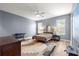 Stylish bedroom features a ceiling fan, neutral walls, and a large window for natural light at 6551 Se 11Th Loop, Ocala, FL 34472
