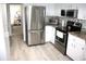 Updated kitchen features modern stainless-steel appliances, sleek countertops, and white cabinetry at 8650 Sw 108Th Pl, Ocala, FL 34481