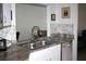 A kitchen view showcasing granite countertops, a stainless steel sink and appliances, and white cabinets at 8650 Sw 108Th Pl, Ocala, FL 34481