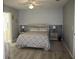 Main bedroom with bed featuring gray geometric patterned bedding and wood bedside tables at 8650 Sw 108Th Pl, Ocala, FL 34481