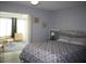 Spacious bedroom with wood headboard, slider door to sunroom, gray walls, and ceiling fan at 8650 Sw 108Th Pl, Ocala, FL 34481