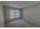 Cozy bedroom with neutral carpet, bright window, and simple blinds at 949 Woodsong Way, Clermont, FL 34714