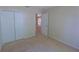 Bedroom with view through doorway, white closet and neutral carpet at 949 Woodsong Way, Clermont, FL 34714
