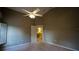 Bedroom with neutral walls and carpets, featuring a ceiling fan and open door at 949 Woodsong Way, Clermont, FL 34714