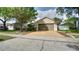 Attractive single-Gathering home shows the two-car garage, tidy landscaping and a paved driveway at 949 Woodsong Way, Clermont, FL 34714