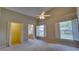 Spacious main bedroom featuring a ceiling fan, ensuite bathroom, and two windows with shutter-style blinds at 949 Woodsong Way, Clermont, FL 34714
