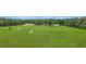 This aerial shot shows an expansive backyard and several buildings on a beautiful day at 975 Cr 542E, Bushnell, FL 33513