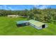 Aerial view of horse barn and attached equipment shelter with a large open grassy field surrounding the buildings at 975 Cr 542E, Bushnell, FL 33513