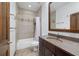 Bathroom with shower-tub combo, granite countertop, and dark wood cabinets at 975 Cr 542E, Bushnell, FL 33513