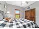 Charming bedroom featuring a plush, patterned comforter and a window with scenic views at 975 Cr 542E, Bushnell, FL 33513