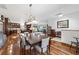 A dining area with a set table, shiny hardwood floors, sightlines to the kitchen, and views to the living room at 975 Cr 542E, Bushnell, FL 33513