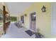 View of the covered front porch with rocking chairs and decorative glass front door at 975 Cr 542E, Bushnell, FL 33513