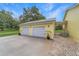 Spacious two-car garage with modern doors, complemented by well-manicured landscaping at 975 Cr 542E, Bushnell, FL 33513