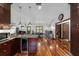 Open layout kitchen featuring hardwood floors, granite countertops, an island with seating, and stainless steel appliances at 975 Cr 542E, Bushnell, FL 33513