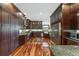 Expansive kitchen with stainless steel appliances, generous granite countertop space, and dark wooden cabinetry at 975 Cr 542E, Bushnell, FL 33513