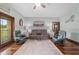 The living room features hardwood floors, a ceiling fan, two chairs, a couch, and a rug at 975 Cr 542E, Bushnell, FL 33513