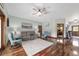 The living room offers hardwood floors, a ceiling fan, two chairs, a couch, and access to other rooms at 975 Cr 542E, Bushnell, FL 33513